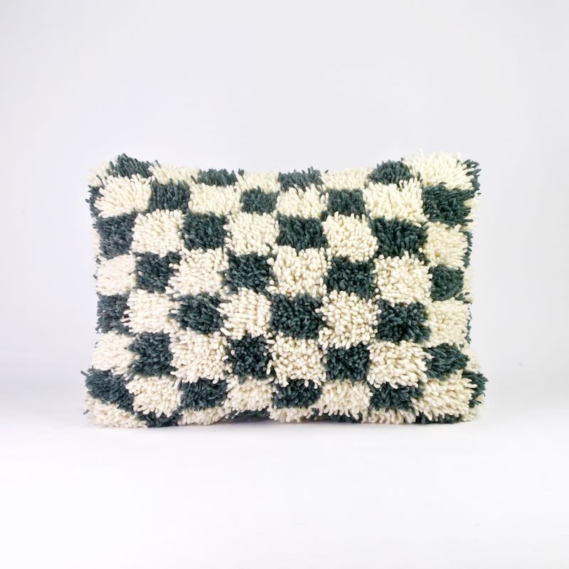 Checkered Moroccan wool pillow in size 40x60 cm. The pillow is standing in front a white background.