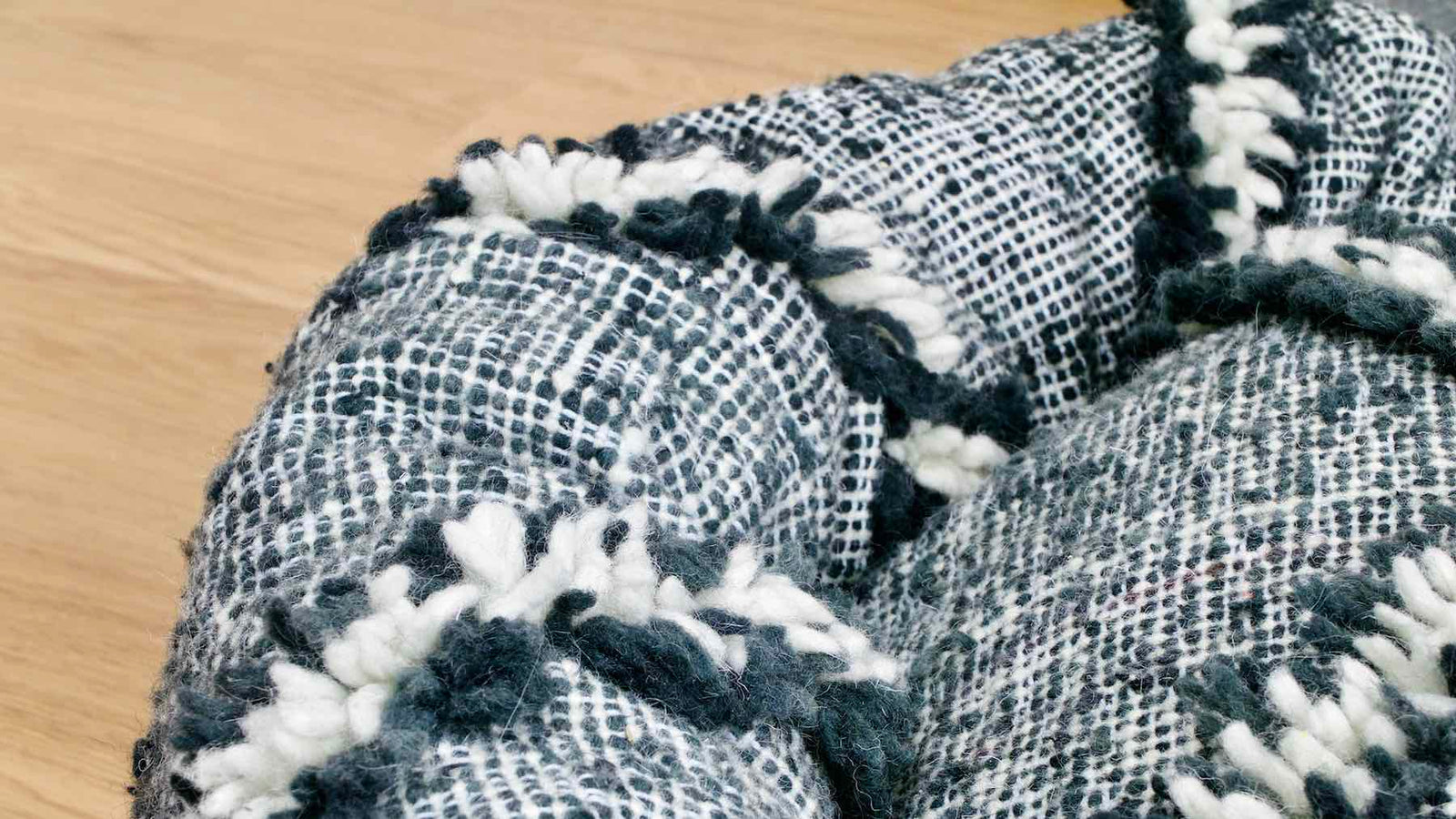 Zoom on a customized dog bed that is made from a black and white Moroccan Kilim wool rug.