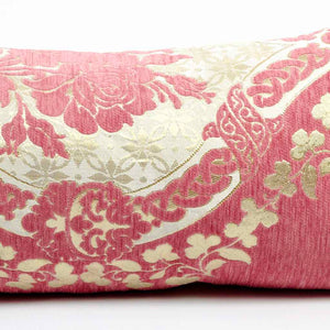 Nahaufnahme eines rosa Dekokissens mit floralem Muster in gold. Das Kissen hat ein typisches Marokko Design.