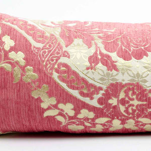 Nahaufnahme links eines rosa Dekokissens mit floralem Muster in gold. Das Kissen ist typisch marokkanisch.