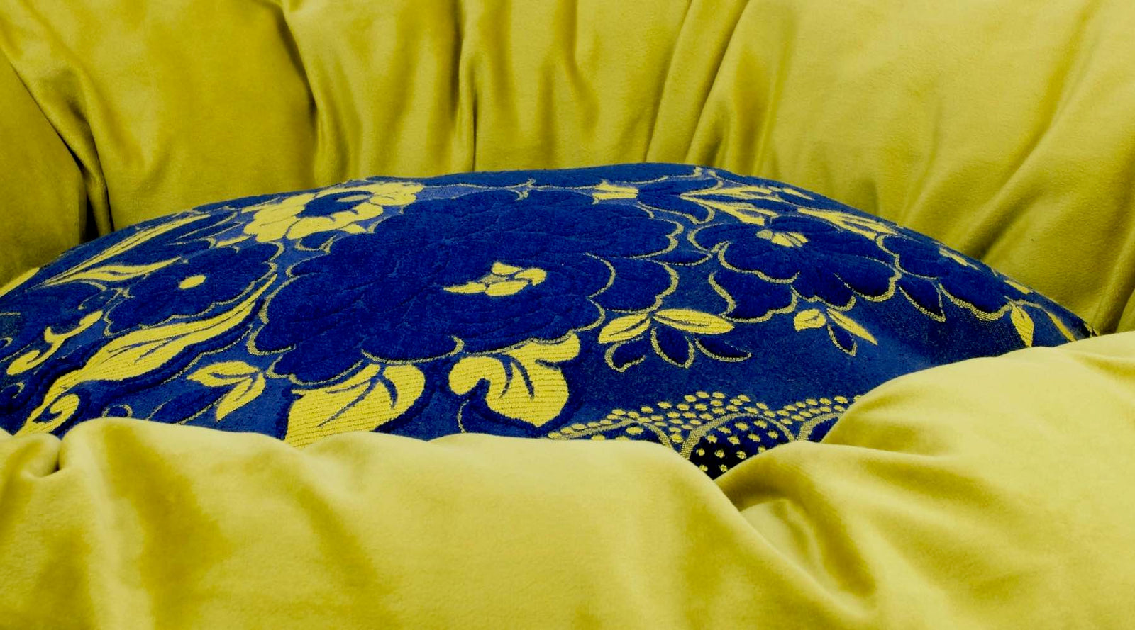 Zoom auf ein blau gelbes Hundebett gefüllt mit Schweizer Wolle.