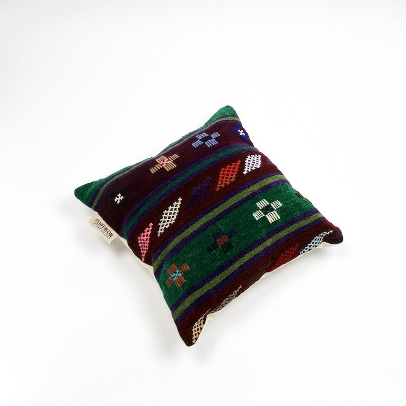 Brown rug cushion in front of white background.