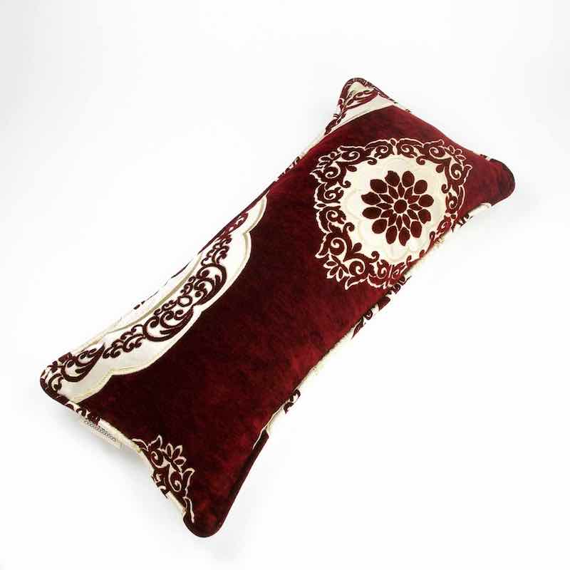 Marokkanisches rotes Sofakissen aus Samt vor weissem Hintergrund. 