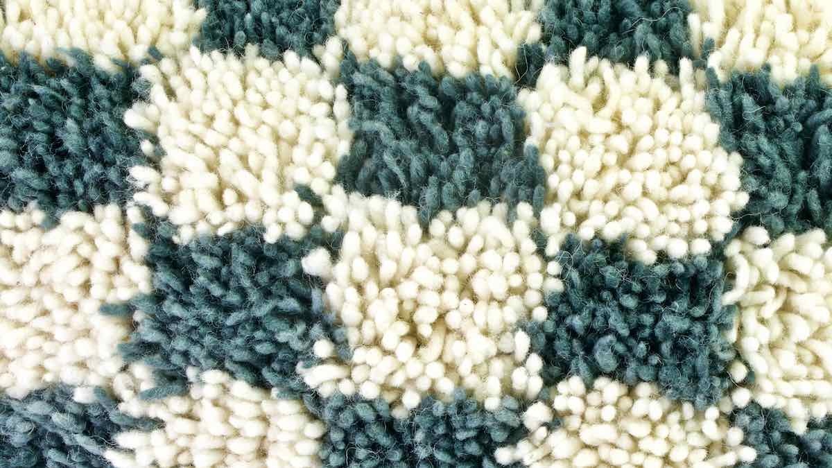 Zoom auf eine grau weiss kariertes Fluffikon Sofakissen hergestellt aus einem marokkanischen Teppich.