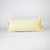 Beige Fluffikon lumbar decorative pillow standing in front of white background.