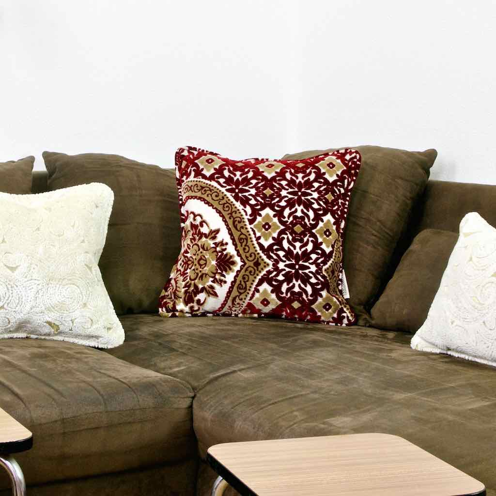 Red Yellow Moroccan throw pillow on a brown couch.