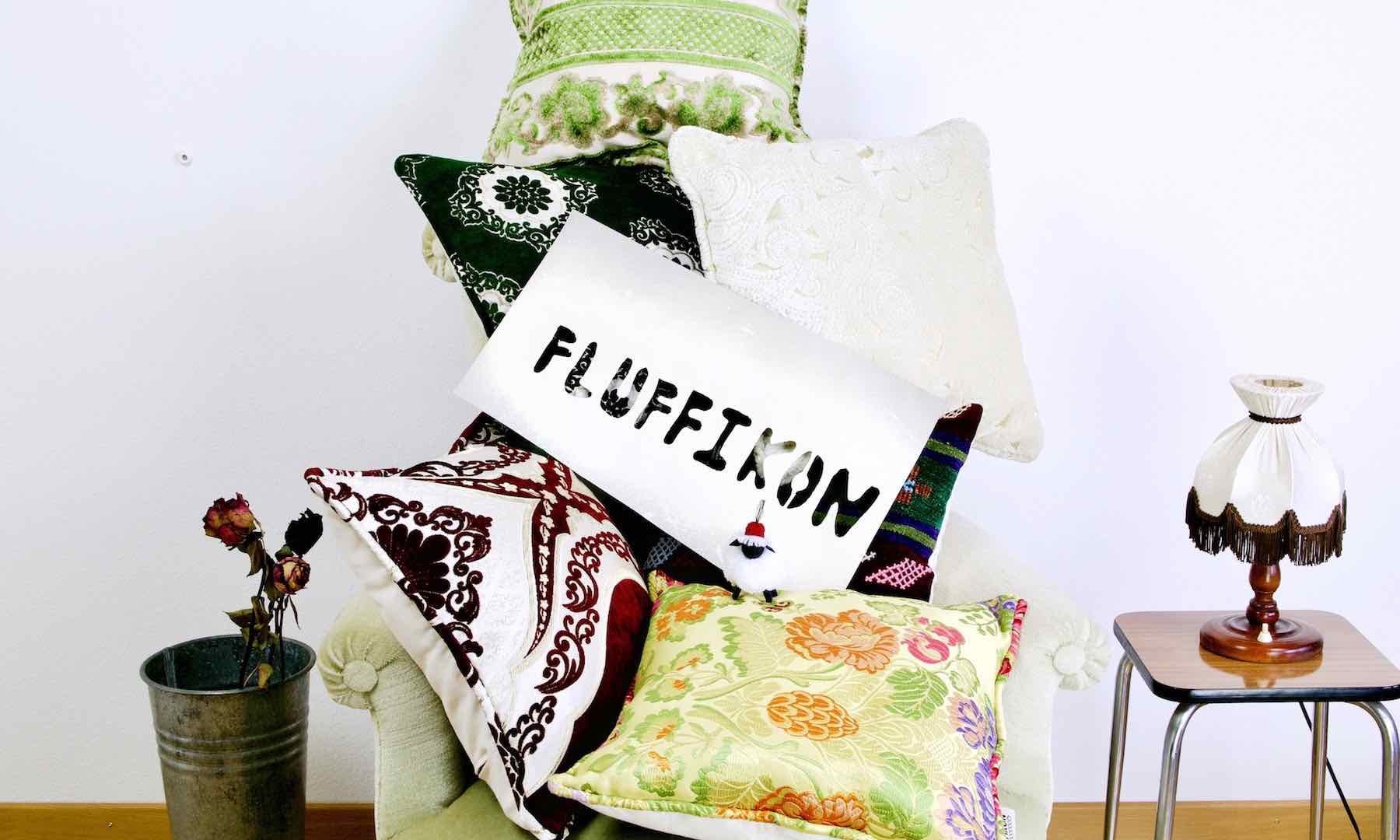Multiple Fluffikon Moroccan pillows on a green velvet chair.