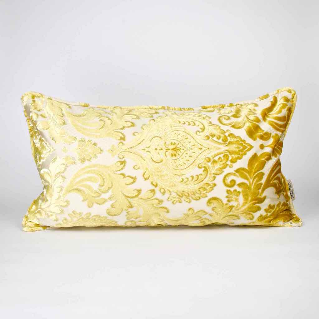 Gold oversized Fluffikon couch pillow standing in front of white background.