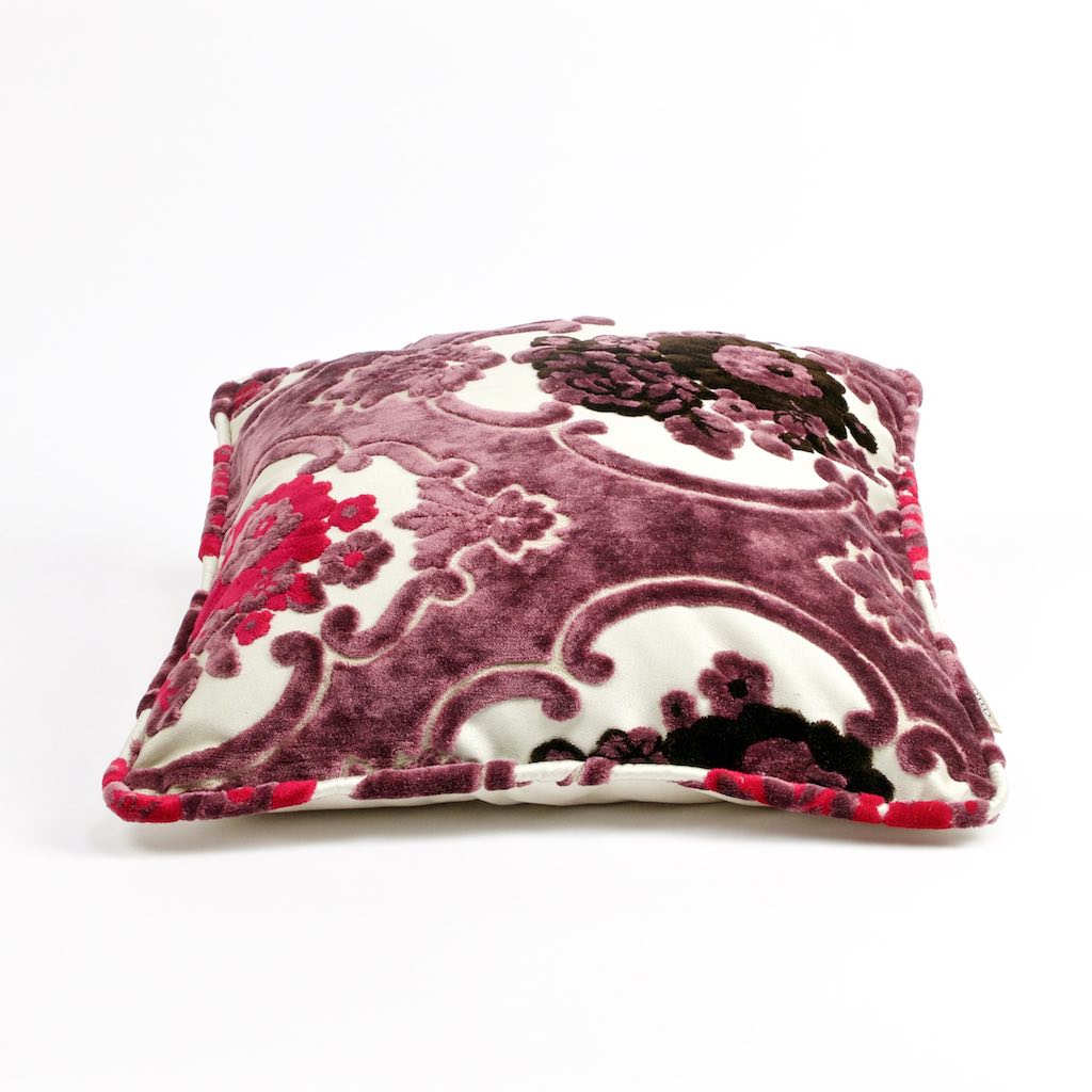 Liegendes Lila Fluffikon Samtkissen mit Blumenmuster.