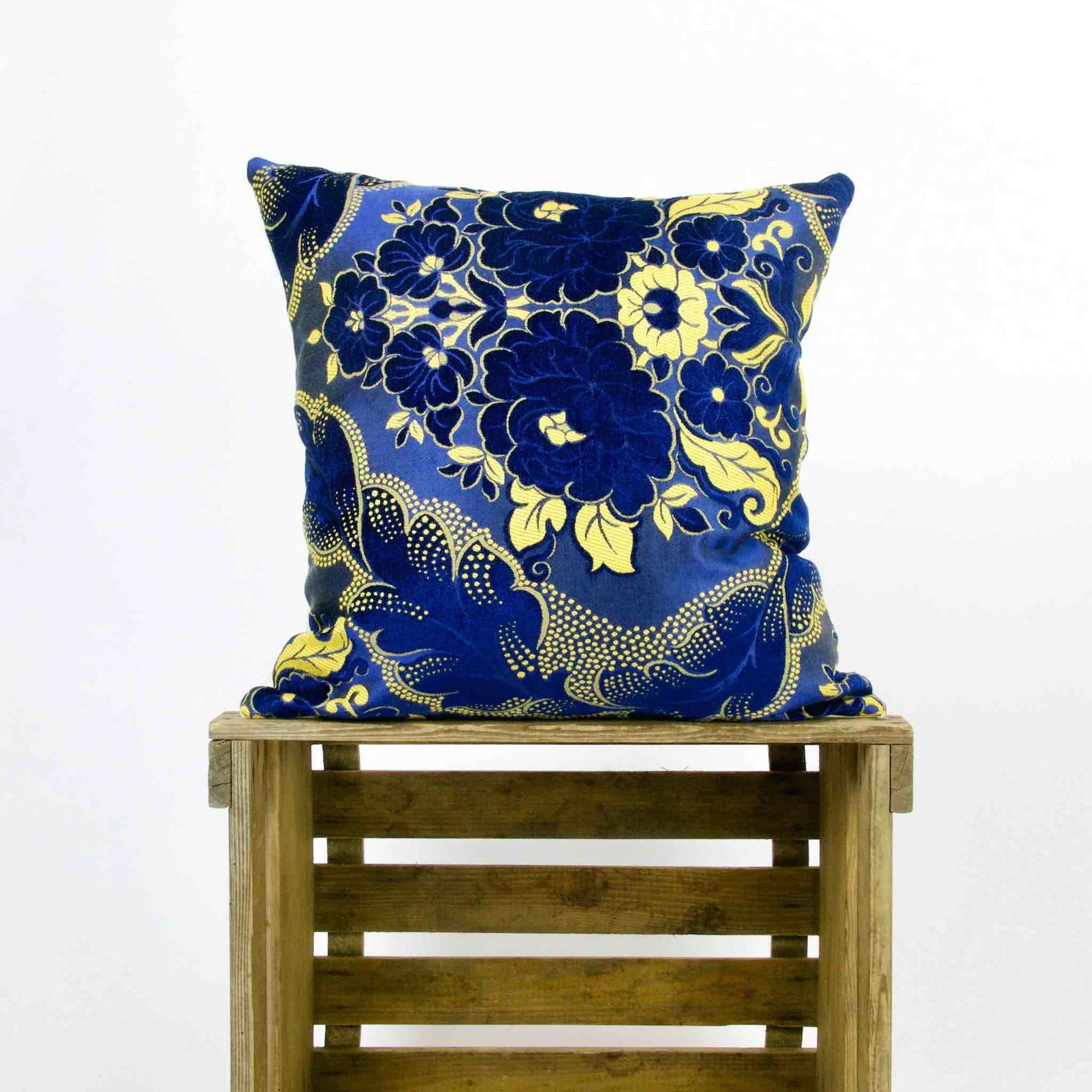 Yellow Blue sofa pillow standing on a wooden box