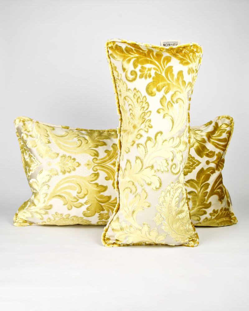 Two golden velvet throw pillows standing in front of each other. The pillows are made from traditional Moroccan fabrics.