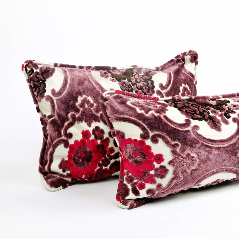 Two throw pillows made from floral velvet fabric. The Fluffikon pillows stand in front of each other.