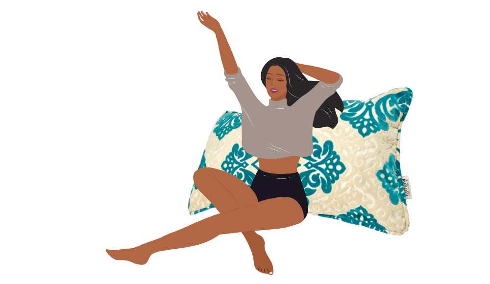 A woman is leaning against a Fluffikon large XXL throw pillow. 