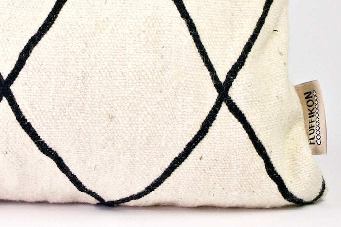 Zoom on the corner of a black and white Fluffikon Kilim wool pillow.