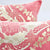 Zoom on two blush pink Fluffikon throw pillows with a golden floral pattern.