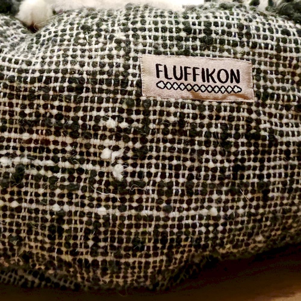 Zoom on wool of a black and white Fluffikon wool dog bed. The sustainable dog bed is filed with sheep wool and made from natural material.