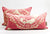 Zwei rosa Fluffikon Dekokissen mit goldenen Blumen Muster. Beide Kissen stehen voreinander.