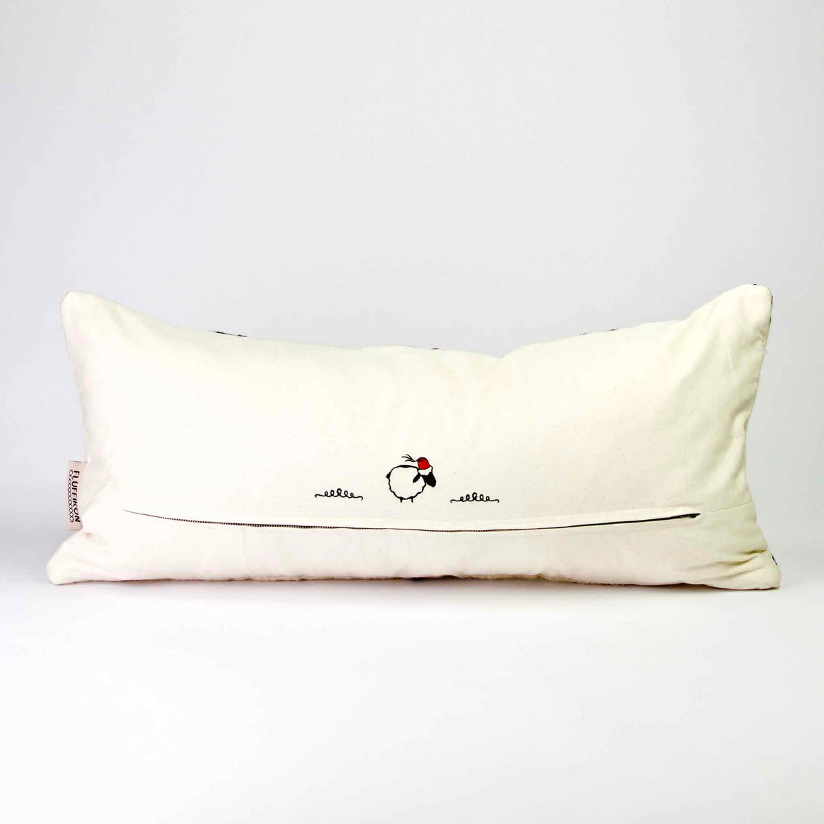 The back of a Fluffikon Kilim pillow standing in front of white background