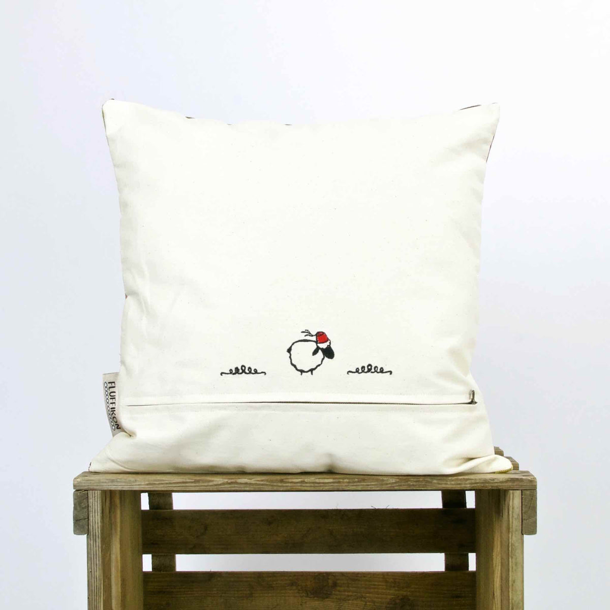 The back of a Green Beige Sofa Pillow on a wooden box.