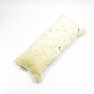 Fluffikon velvet lumbar pillow made from beige moroccan fabric. The pillow is on the ground shown from the top.