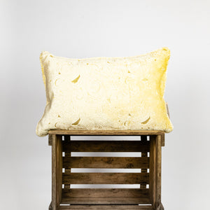 Fluffikon velvet rectangular pillow made from beige moroccan fabric. The pillow is on a wooden box.