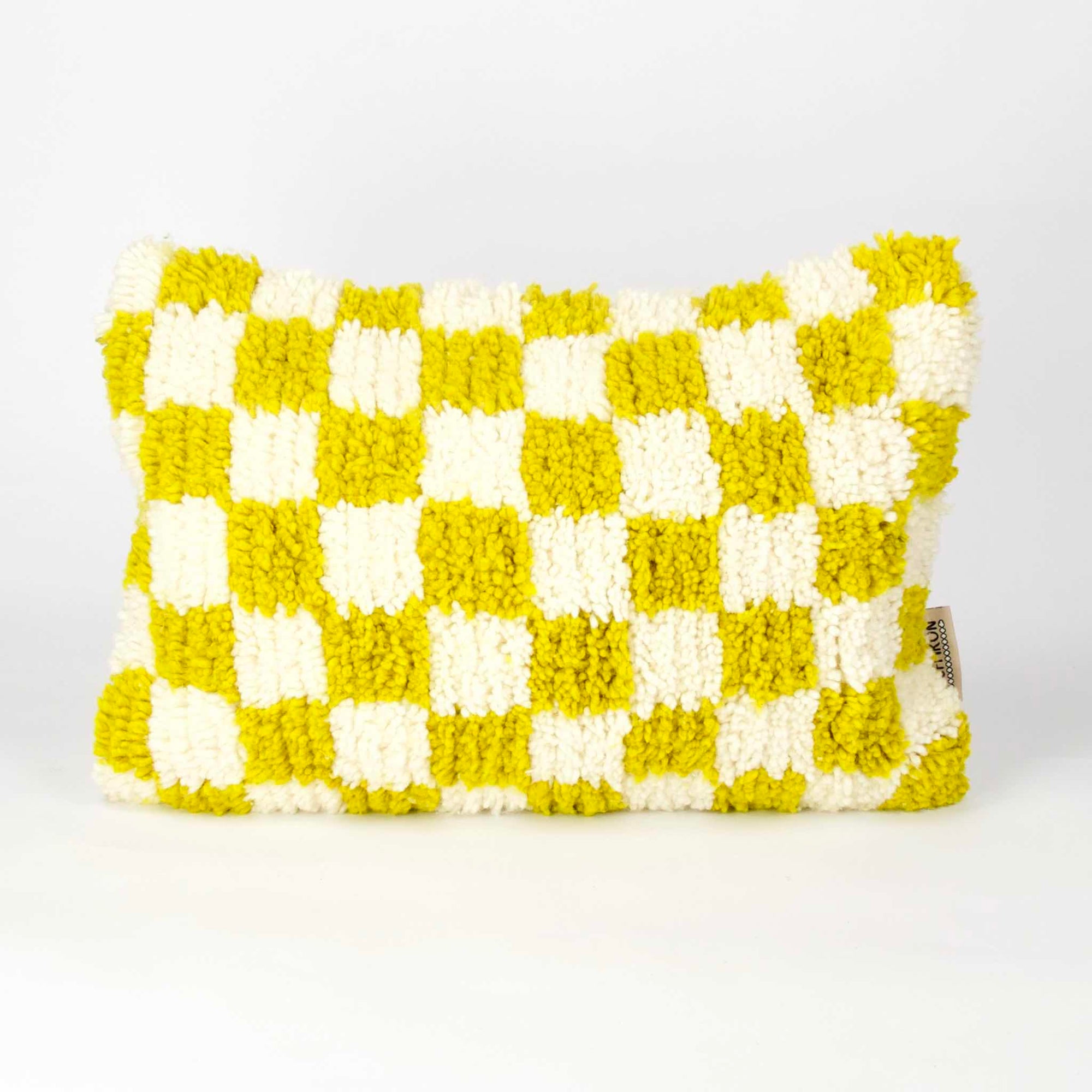 Rectangular Beni Ourain Fluffikon pillow with yellow white checkered pattern. The pillow is made from wool. It stands in front of a white background.