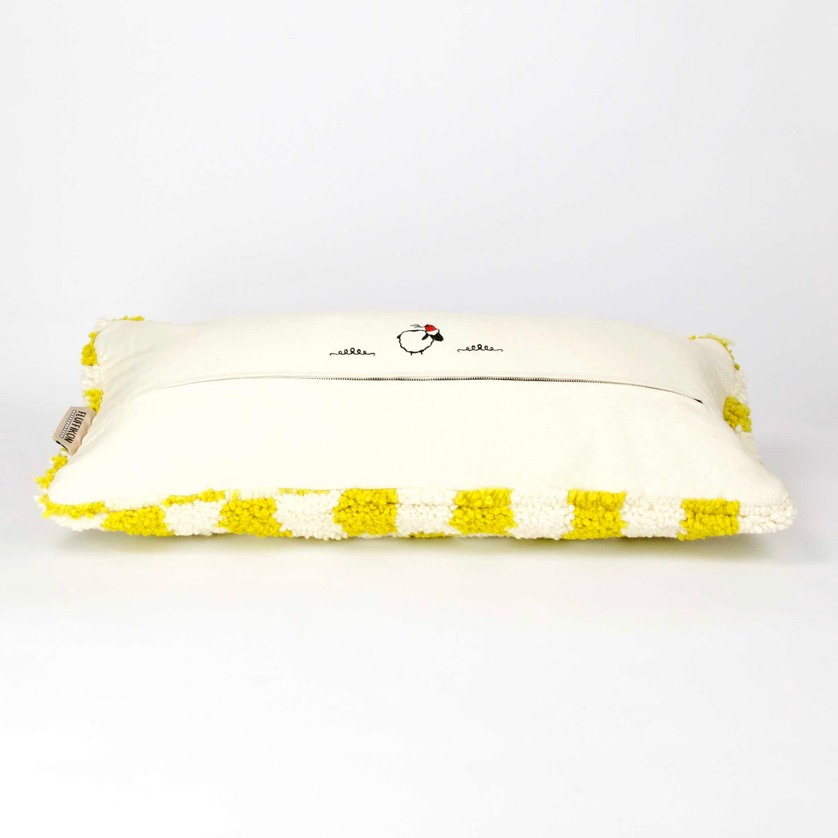 Side view of a Beni Ourain Fluffikon lumbar pillow with yellow white checkered pattern made from a  wool carpet.