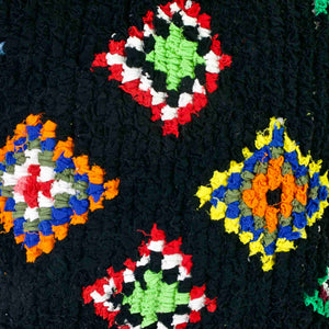 Zoom on black Boucherouite Berber Cushion cover with colorful spots.