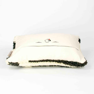 Side view of a black and white Fluffikon rug pillow.