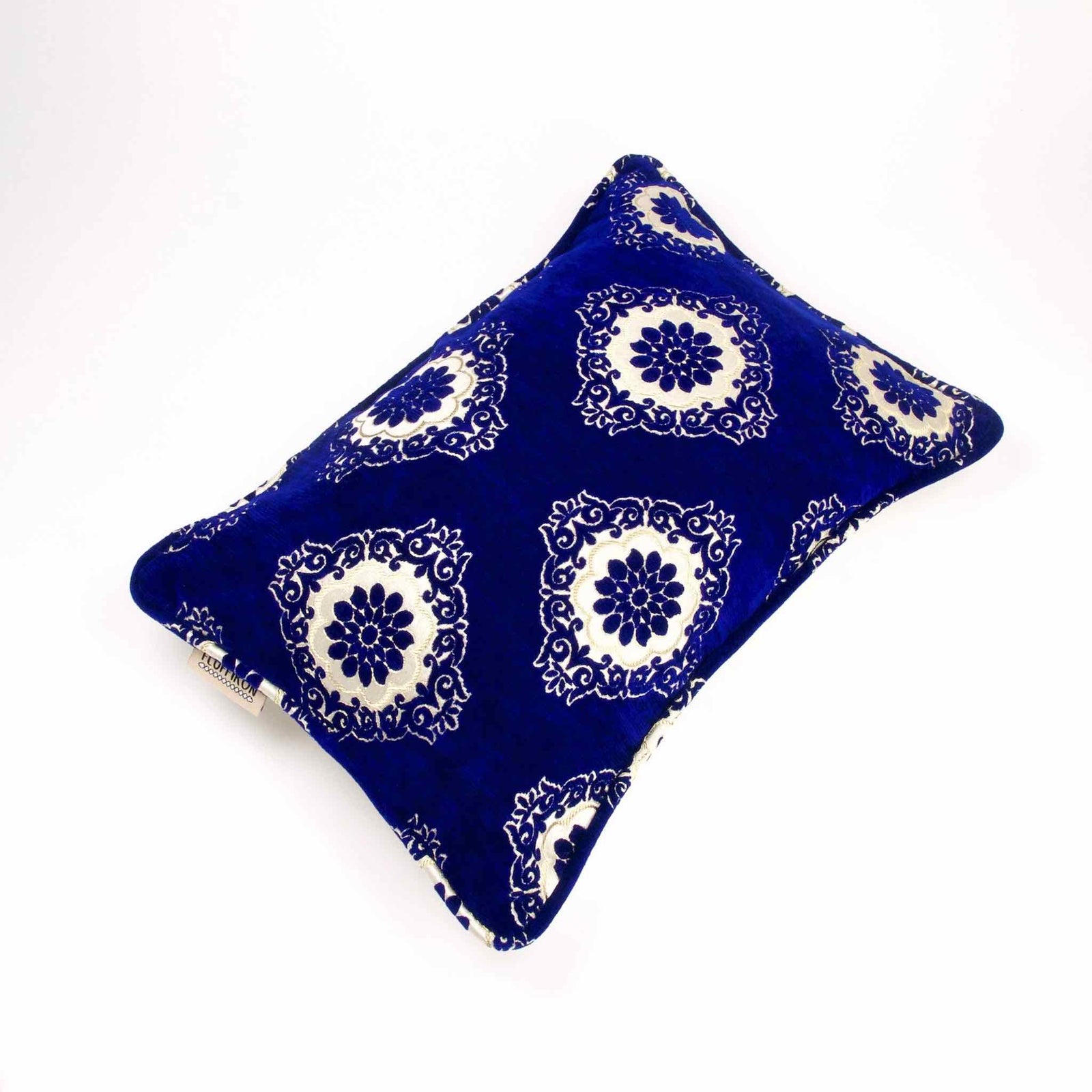 Edles saphirblaues Kissen aus Samt vor weißem Hintergrund