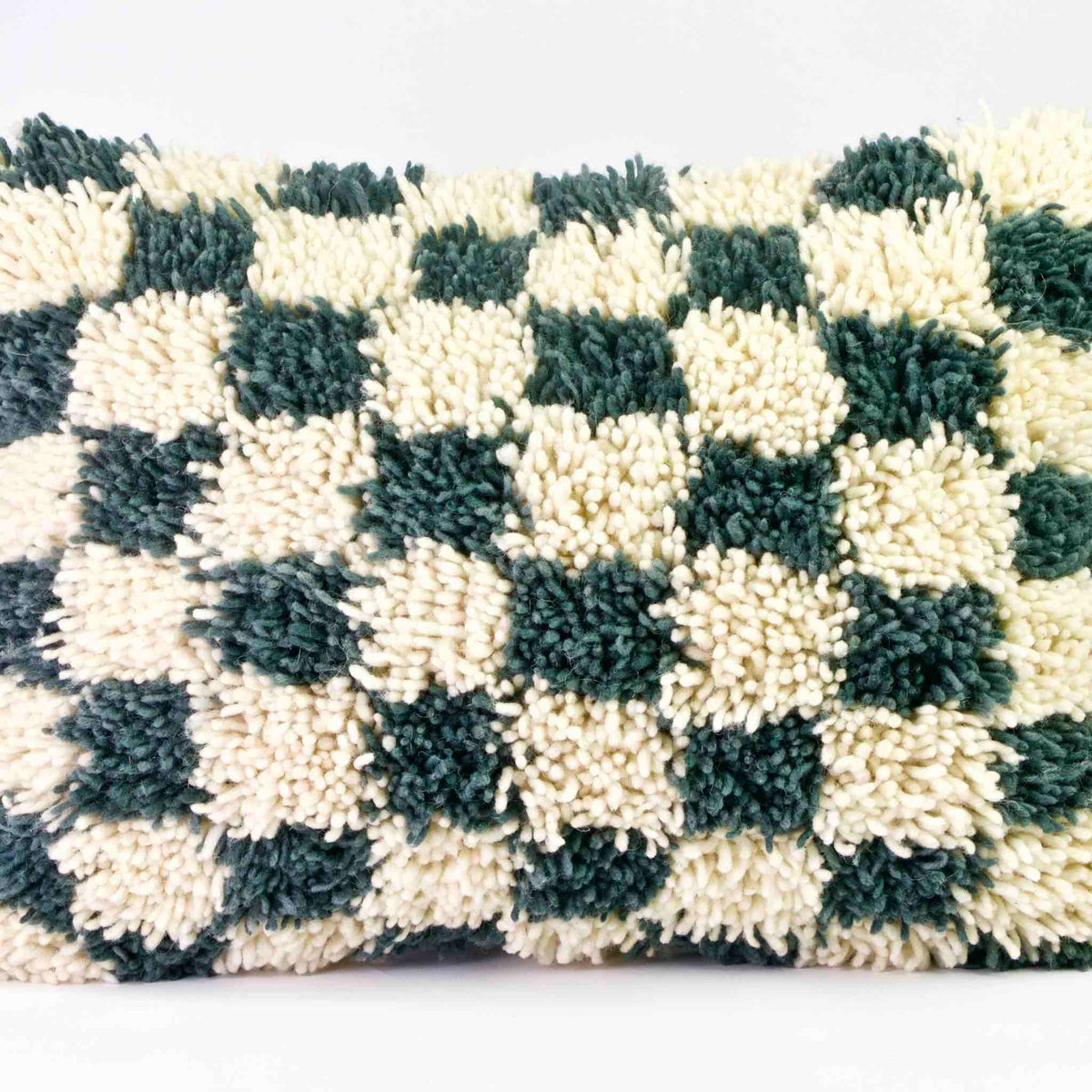 Checkered Moroccan Throw Pillow. The pillow is made of a checkered wool rug.