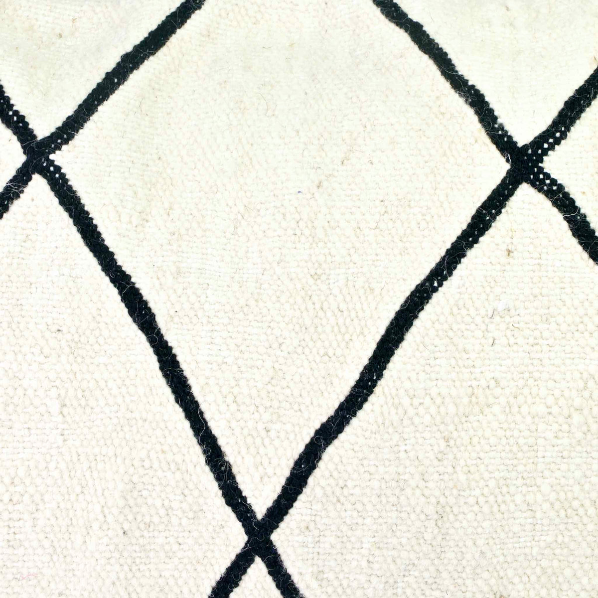 Zoom on the Kilim fabric of a black and white Fluffikon Kilim throw pillow.