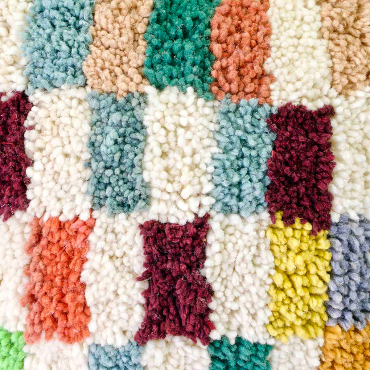 Zoom auf Fluffikon Kinderzimmer Kissen vor weissem Hintergrund. Das Kissen ist bunt kariert.