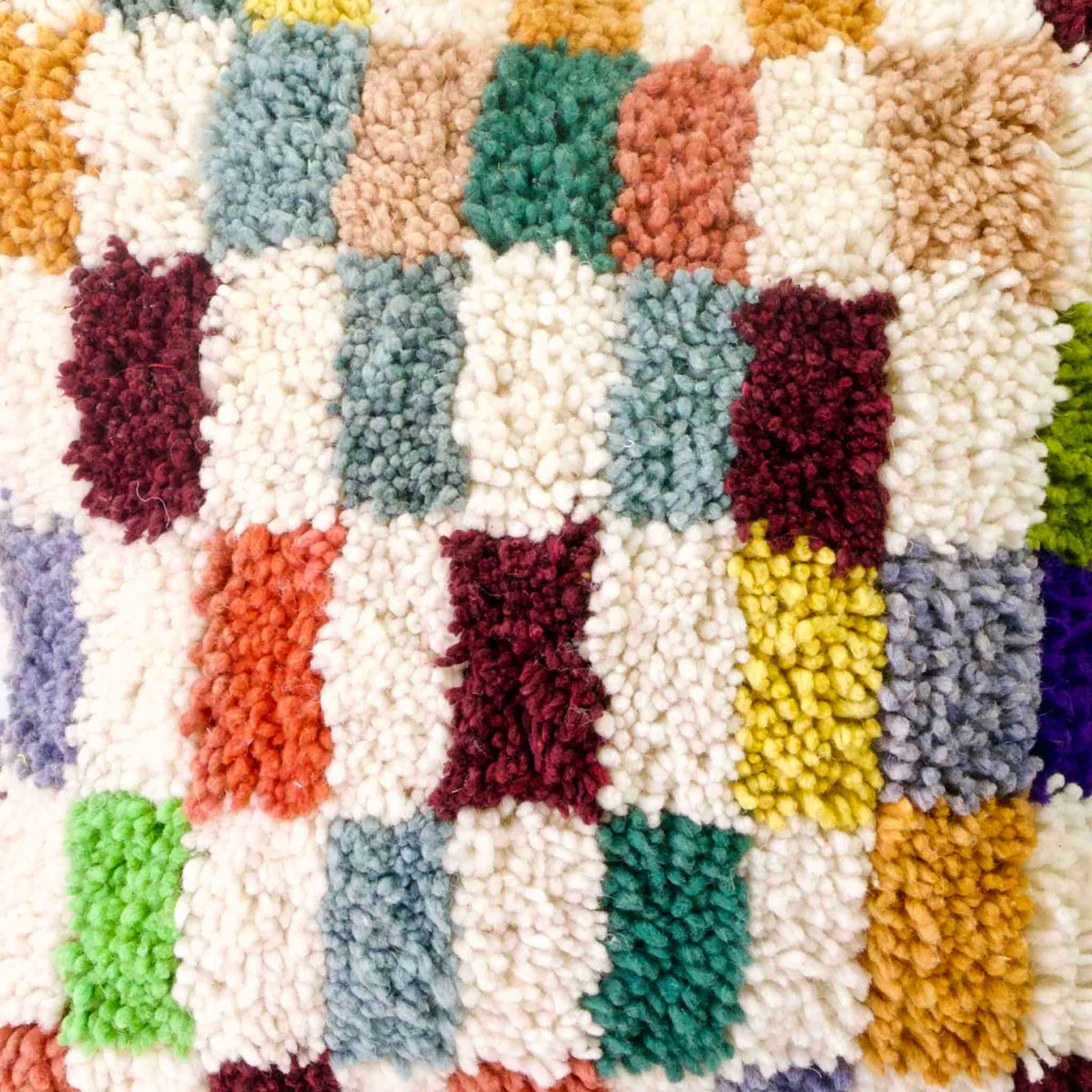 Zoom auf Fluffikon Kinderzimmer Kissen vor weissem Hintergrund. Das Kissen ist bunt kariert.