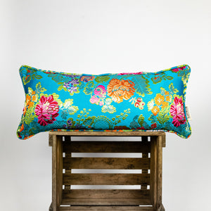 Blue decorative lumbar pillow made from shiny brocade with colourful flowers embroidery.