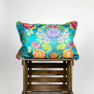 Blue decorative rectangular pillow made from shiny brocade with colourful flowers embroidery.