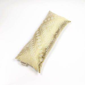 Fluffikon silk lumbar pillow made from golden moroccan fabric. The pillow is shown from the top.
