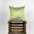 Fluffikon silk square pillow made from green moroccan fabric. The pillow is on a wooden box. Size 45x45 cm.