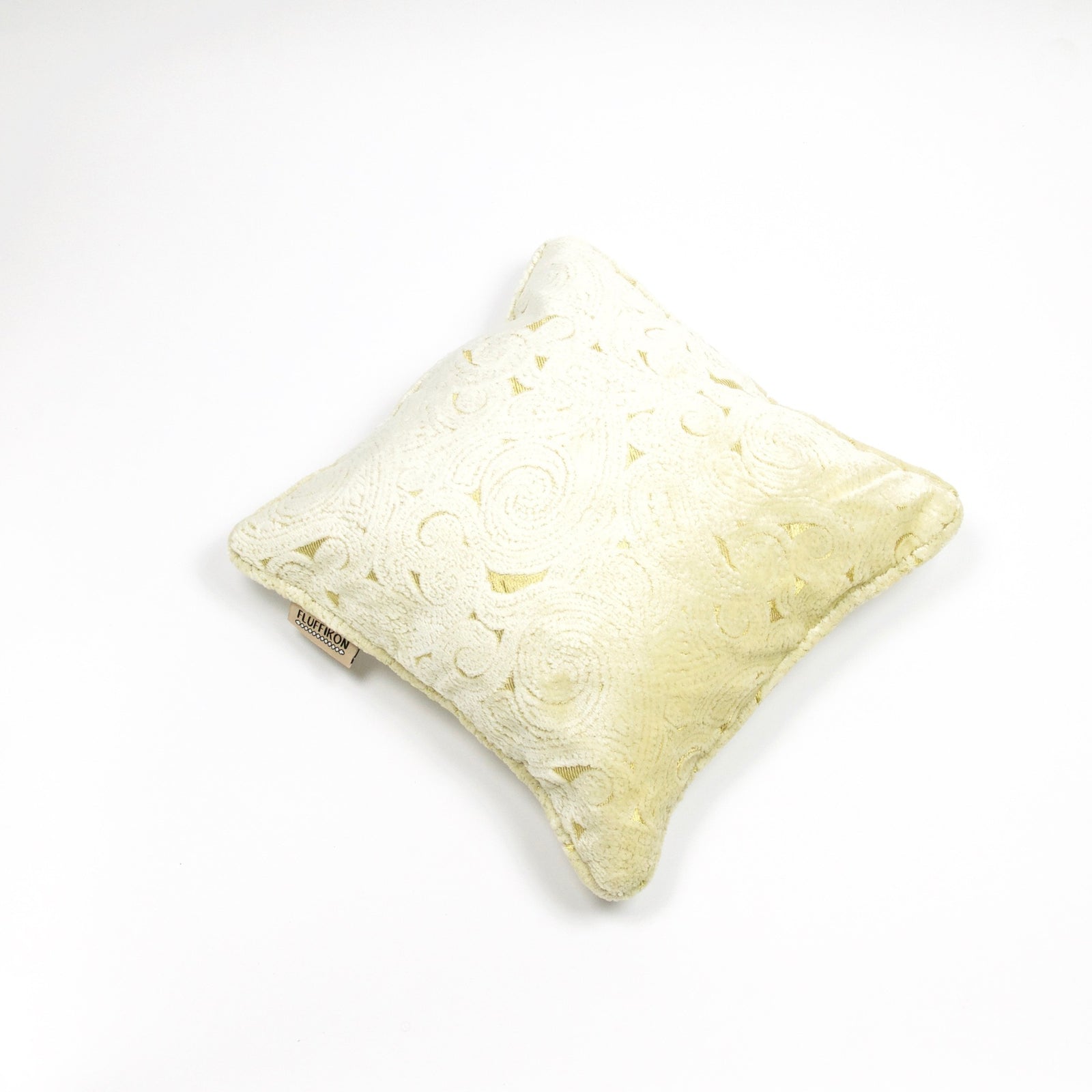 Fluffikon velvet square pillow made from beige moroccan fabric. The pillow is on the ground shown from the top.