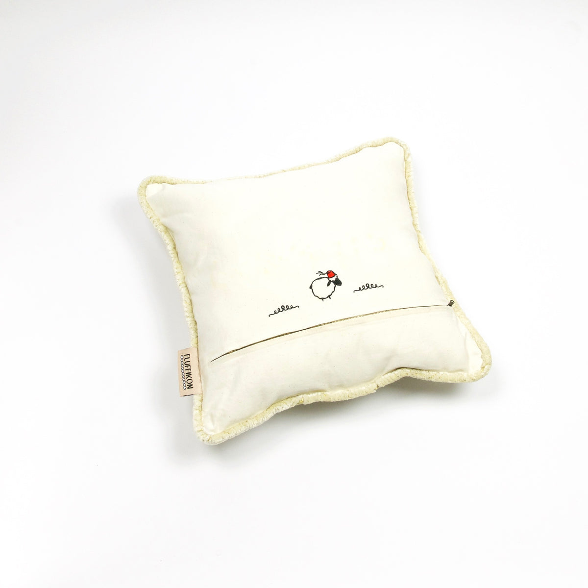 Fluffikon velvet square pillow made from beige moroccan fabric. The pillow is on the ground shown from the back.