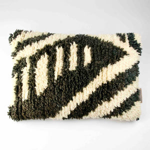 Rechteckiges (40x60 cm) Fluffikon Berber Kissen vor weissen Hintergrund. Das Kissen wurde aus einem Beni Ourain Teppich hergestellt.