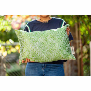 Fluffikon silk rectangular pillow made from green moroccan fabric. The pillow is held by a woman. Size 40x60 cm.