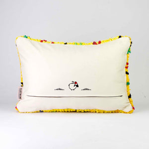 Back view of a yellow Boucherouite throw pillow. The yellow pillow has colorful dots.