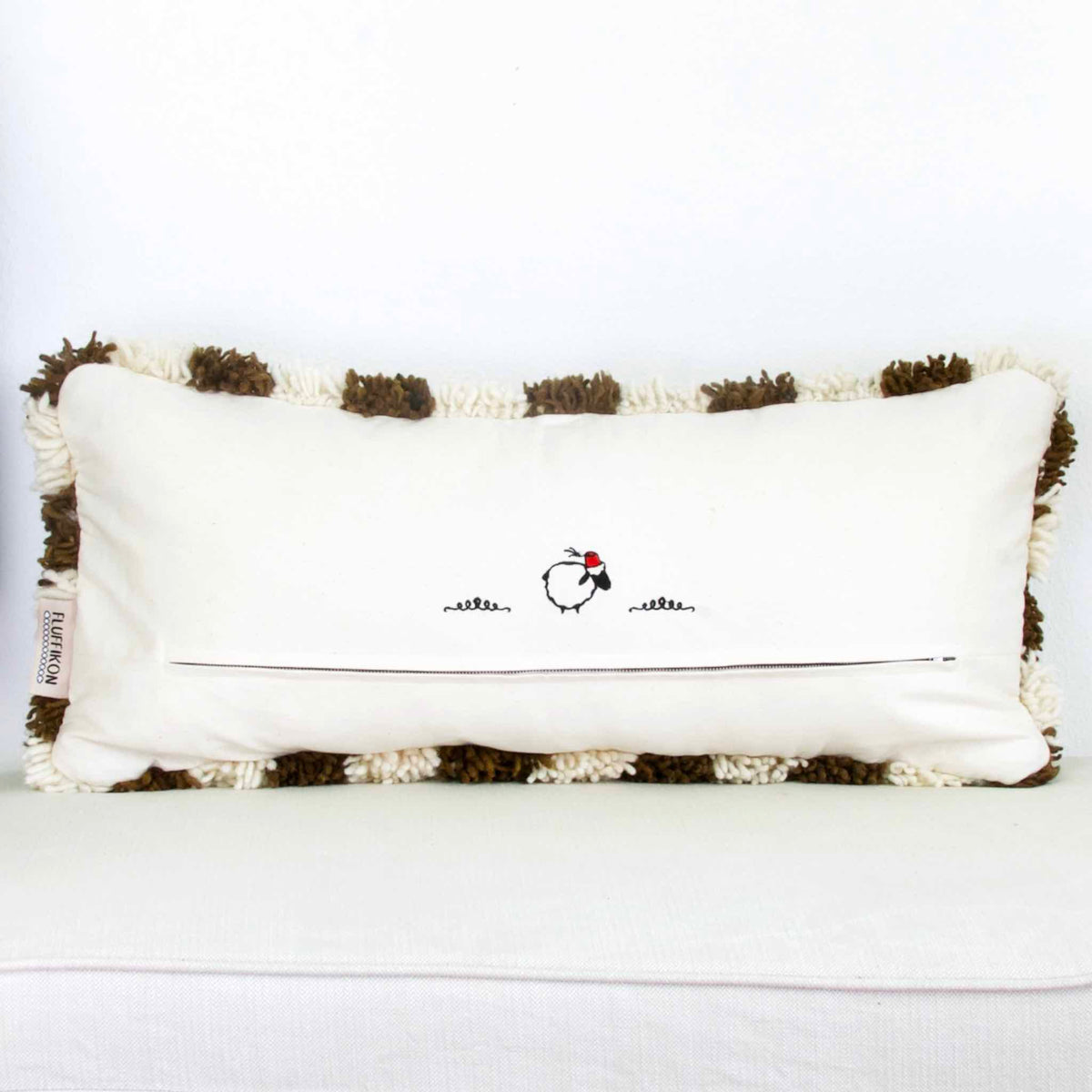 Back view on a brown checkered Fluffikon lumbar pillow. The Berber was made from Beni Ourain wool rug.