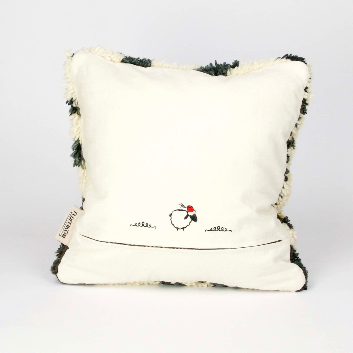 Back view on a vintage rug pillow made from a Moroccan carpet standing.