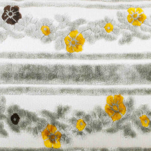 Detailed zoom on a grey velvet fabric with yellow and brown flowers.