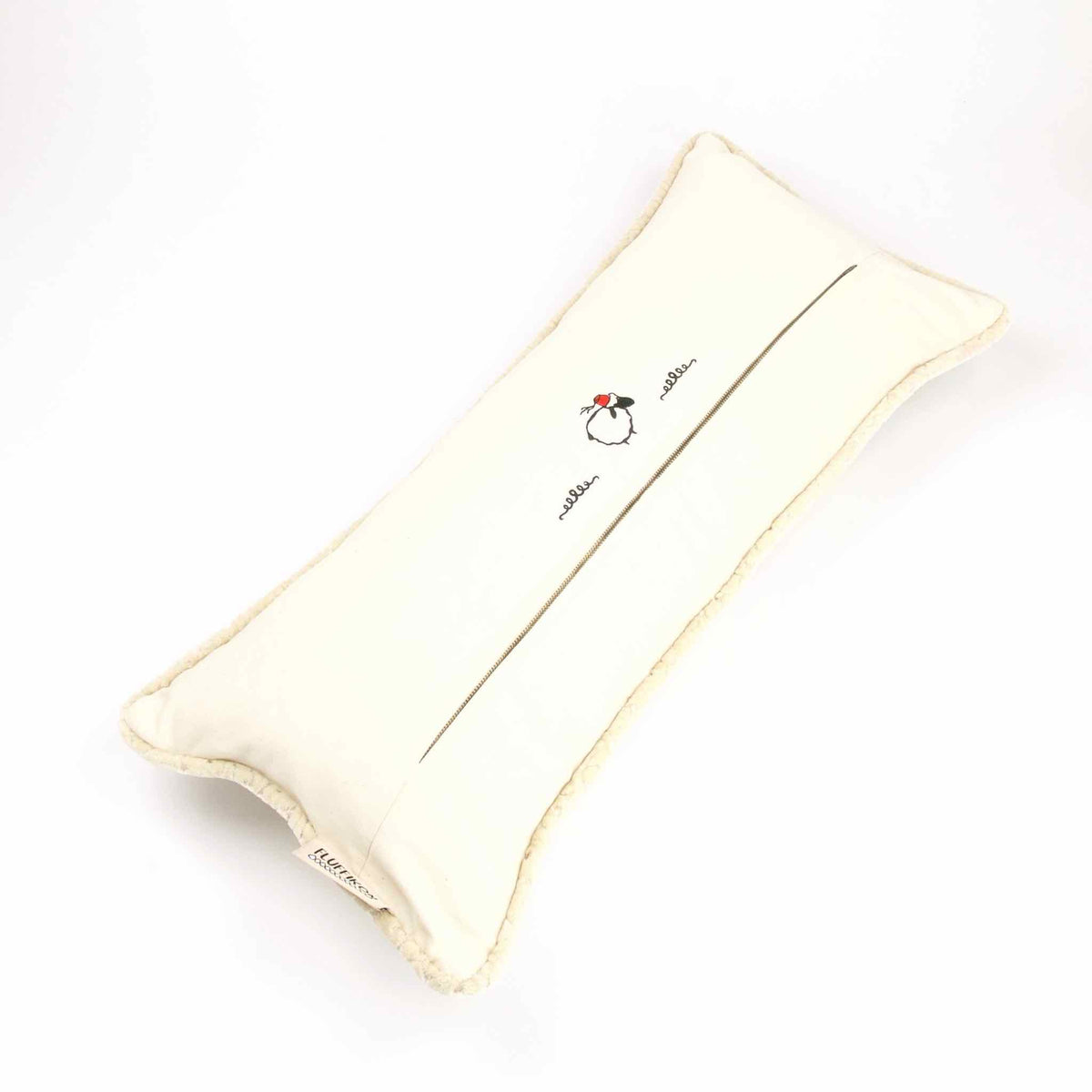The back of a large Moroccan pillow in front of white background.