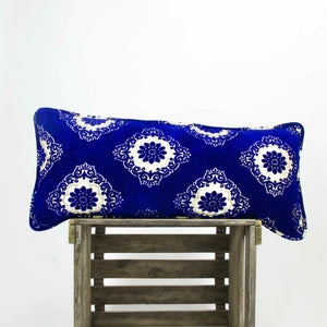 Blue velvet couch pillow on a wooden box.
