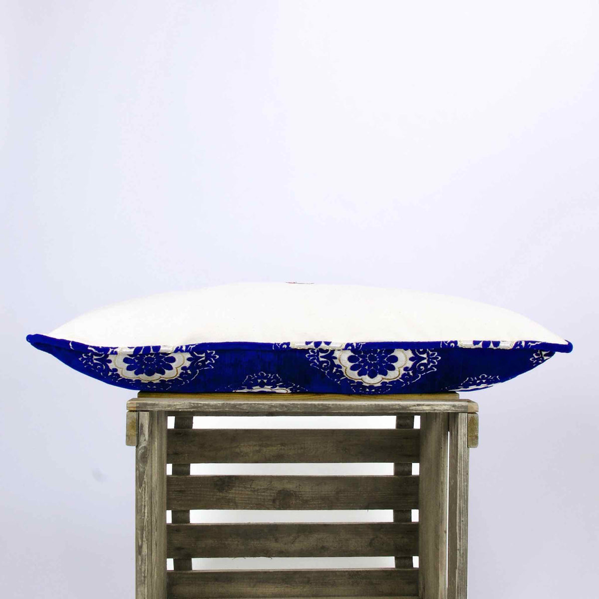 Piped edges of blue velvet couch pillow.