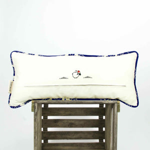 Blue velvet couch pillow on a wooden box. A stitched Moroccan sheep is shown.